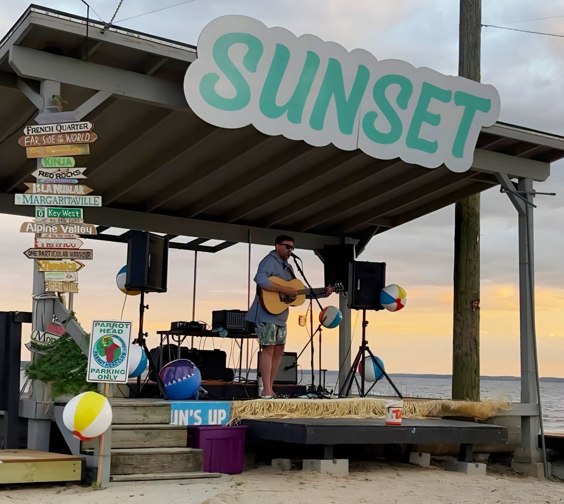 Wide view of the lakefront stage and musician at Sunset Bar & Grill
